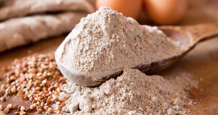 cucchiaio di legno riempito con farina di grano saraceno macinata