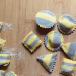 ravioli bicolore al mirtillo sparsi su spianatoia