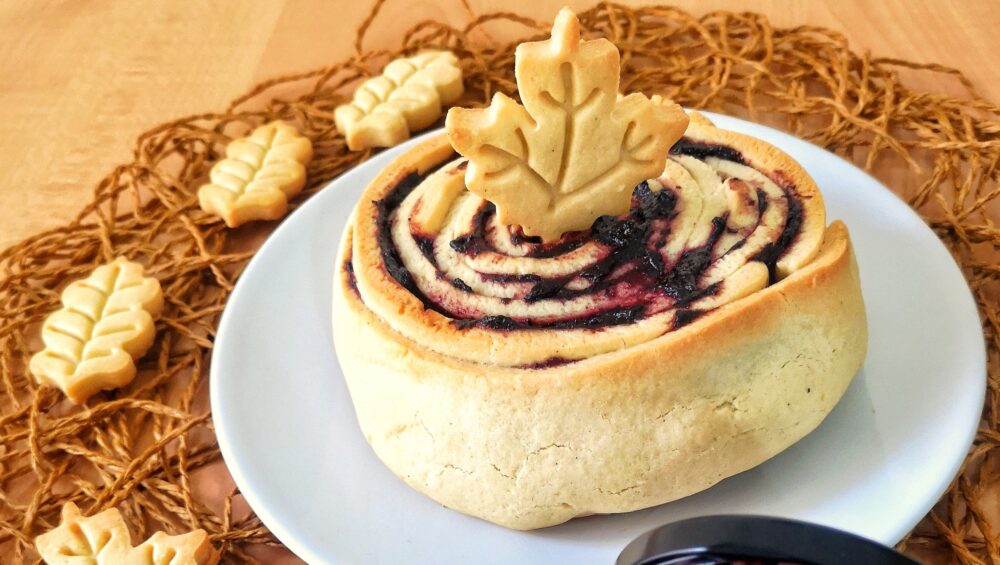 crostata arrotolata con confettura al mirtillo e biscotti a forma di foglia