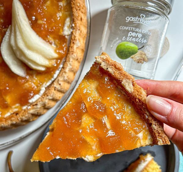 mano che tiene fetta di crostata alla marmellata